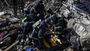 Рятувальники надають допомогу постраждалому на ношах серед руїн після удару дронів у Запоріжжі