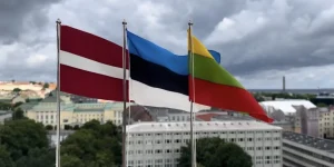 Прапори Естонії, Латвії та Литви на тлі міста під хмарами