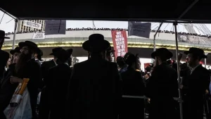 Хареді на протесті проти служби в армії Ізраїлю з плакатом We will never serve in the IDF army