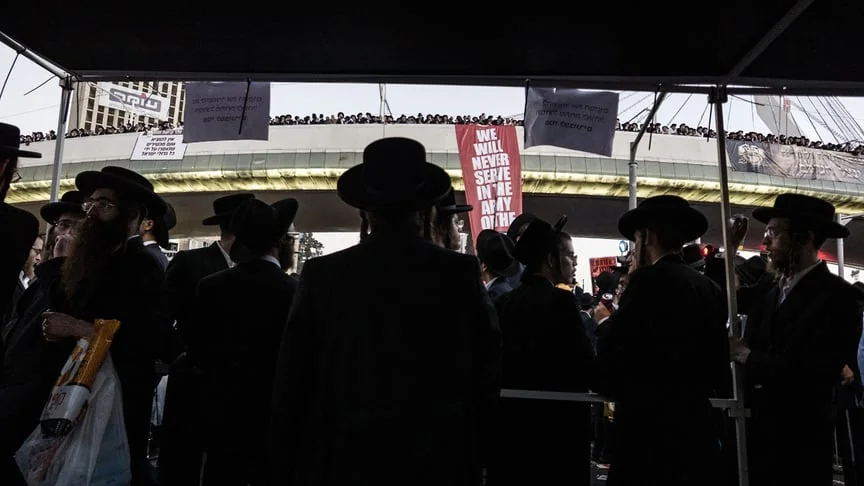 Хареді на протесті проти служби в армії Ізраїлю з плакатом We will never serve in the IDF army