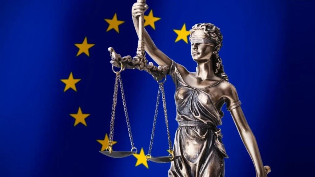 Статуя Феміди з вагами на тлі прапора ЄС як символ справедливості
