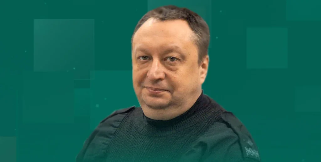 Портрет чоловіка в темному светрі на зеленому графічному тлі з квадратами