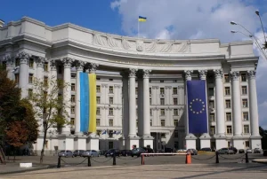 Біла колонадна будівля МЗС України з прапорами України та ЄС